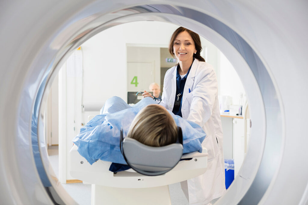 A female doctor overseeing a patient undergoing a CT scan.