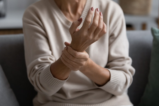 an older woman grasping her wrist.