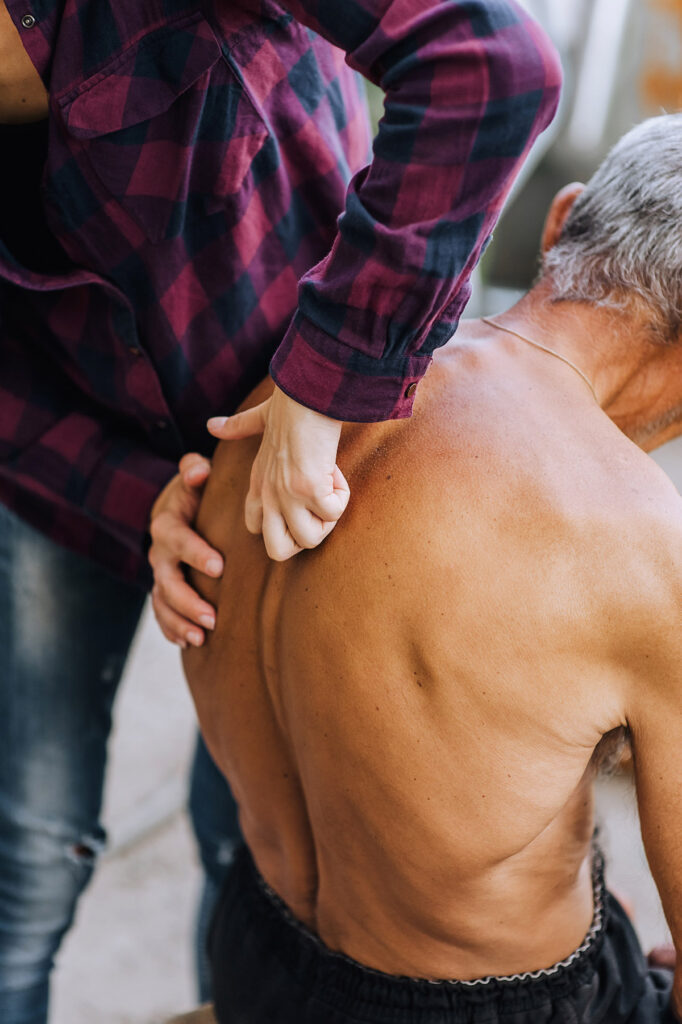 An elder person with noticeable scoliosis.